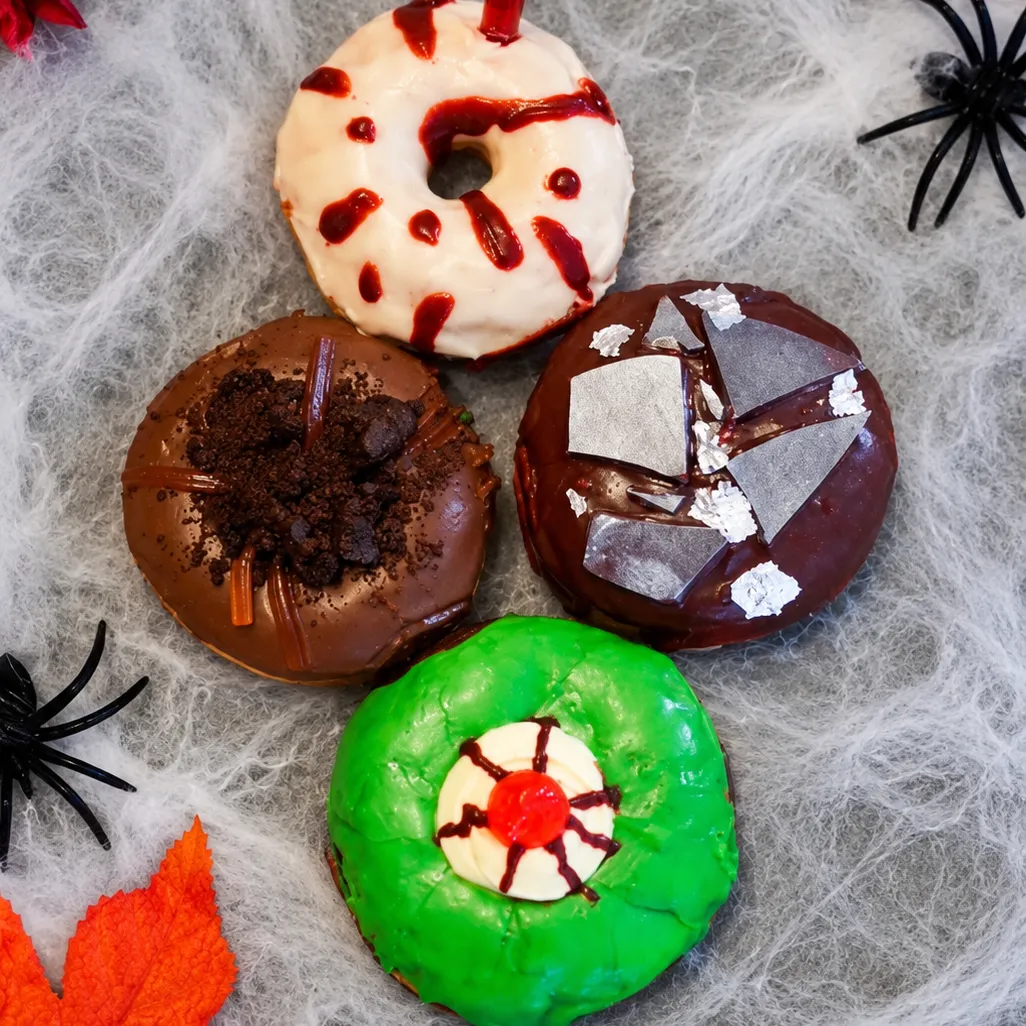 Vonuts Halloween box: four Halloween donuts on a spiderweb background